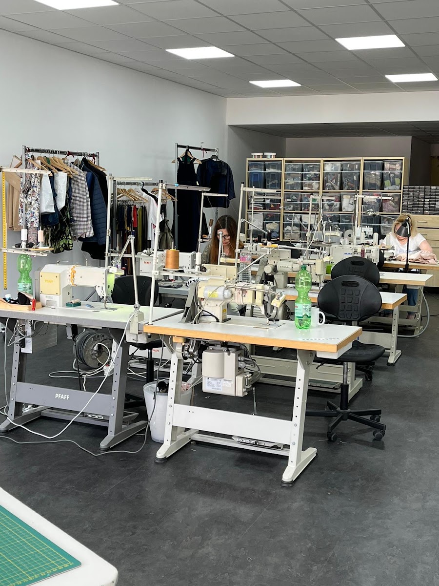 Werkstatt mit mehreren Industrie-Nähmaschinen und Näherinnen bei der Arbeit
